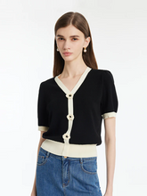 a lady in a black v-neck knit top with jeans